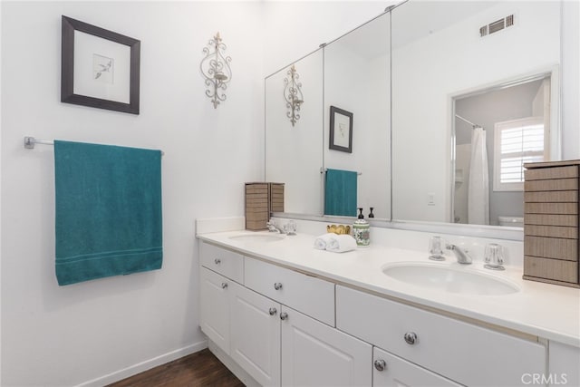 bathroom with vanity, wood-type flooring, and toilet