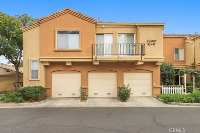 view of property with a garage and a balcony