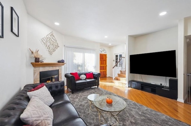 living room with a tile fireplace and hardwood / wood-style floors