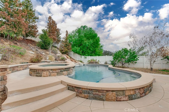 view of pool with an in ground hot tub and a patio