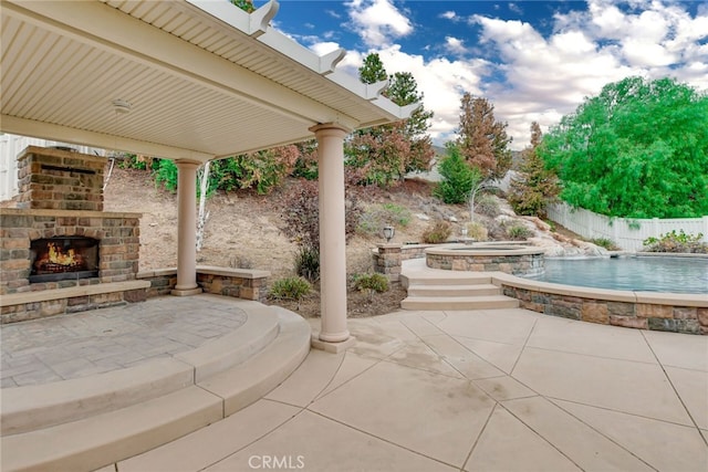 view of patio featuring a fenced in pool and an outdoor stone fireplace