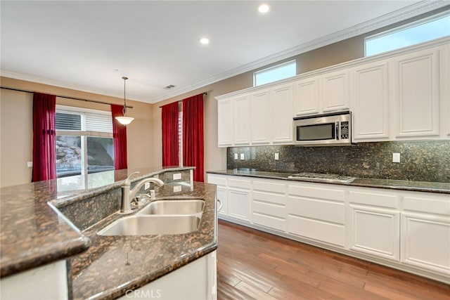 kitchen featuring light hardwood / wood-style floors, white cabinetry, stainless steel appliances, and dark stone counters