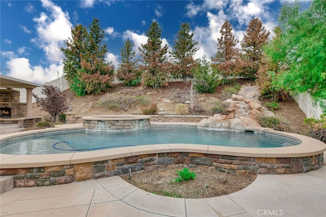 view of pool with a hot tub, pool water feature, and a patio