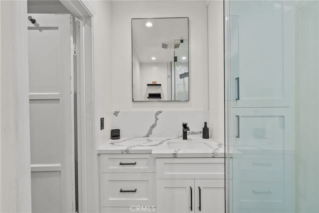 bathroom featuring vanity and a shower with door