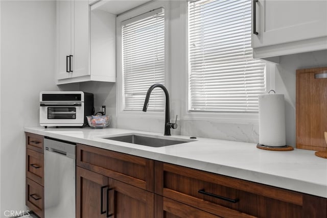 kitchen featuring white cabinetry, dishwasher, and sink