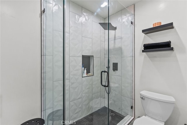 bathroom with toilet and a shower with door