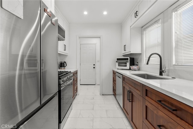 kitchen with white cabinetry, sink, and appliances with stainless steel finishes