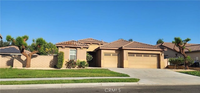 mediterranean / spanish-style home featuring a garage and a front lawn