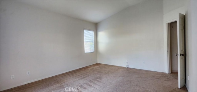 carpeted empty room featuring lofted ceiling