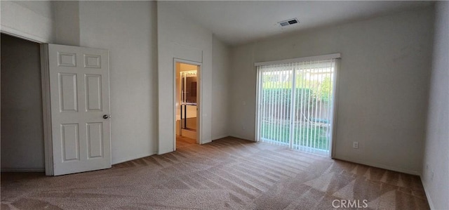 unfurnished bedroom featuring light carpet and vaulted ceiling