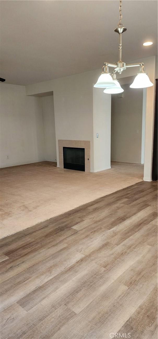 unfurnished living room featuring light colored carpet and a tile fireplace