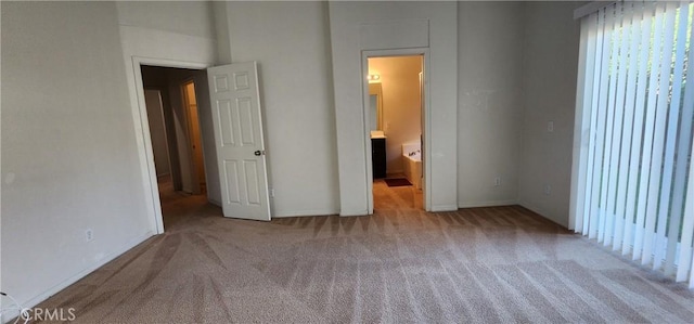 unfurnished bedroom with connected bathroom and light carpet