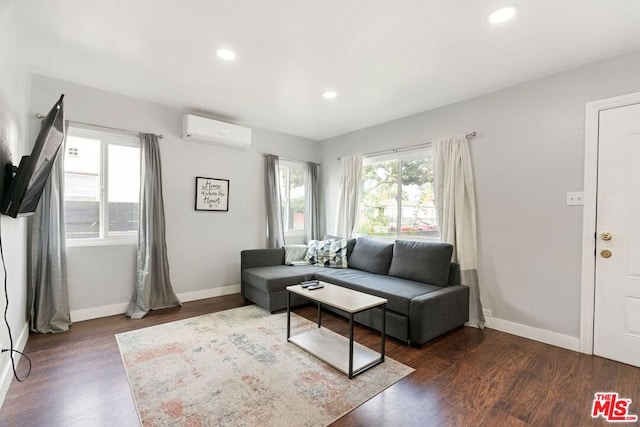 living room with dark hardwood / wood-style flooring and an AC wall unit