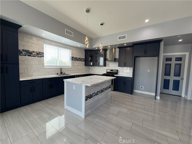 kitchen featuring sink, a center island, stainless steel range, and decorative backsplash