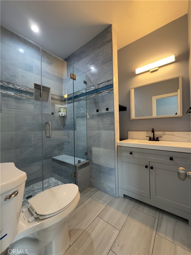 bathroom with toilet, an enclosed shower, vanity, and tile patterned floors