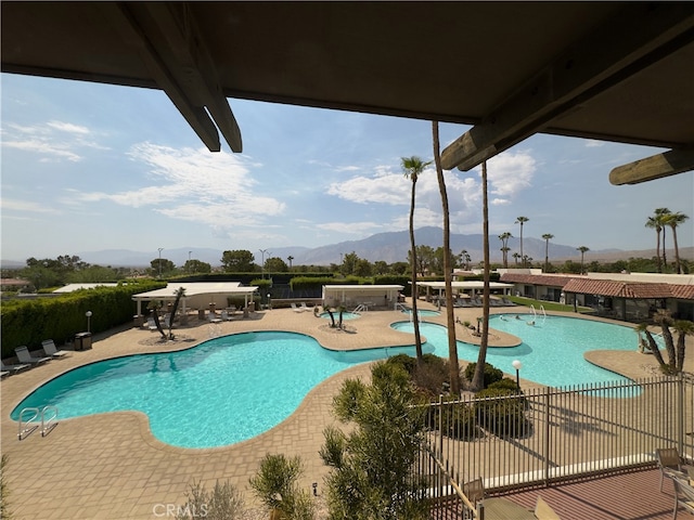 view of swimming pool featuring a patio and a mountain view