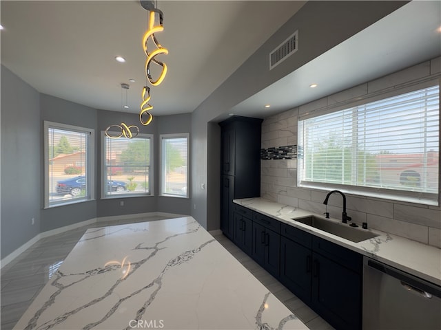 kitchen featuring decorative backsplash, light stone countertops, stainless steel dishwasher, pendant lighting, and sink