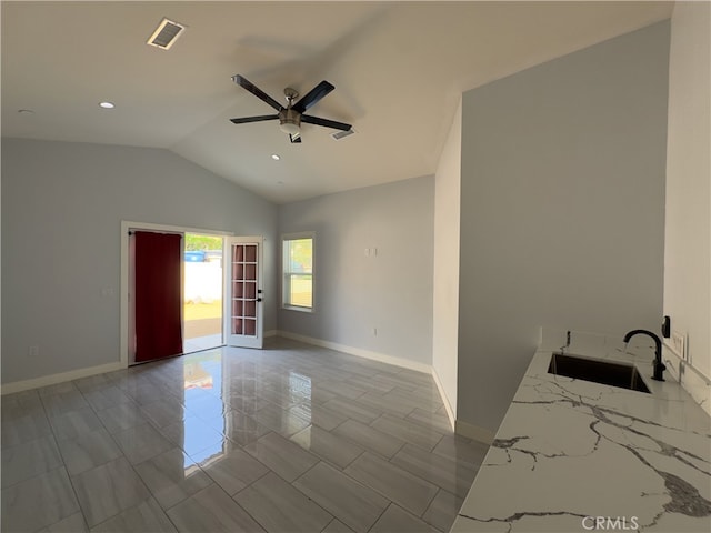 spare room featuring lofted ceiling, sink, and ceiling fan