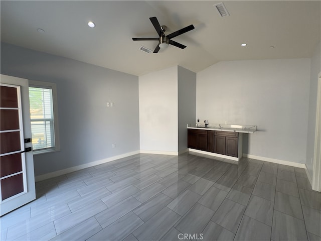 unfurnished living room with sink, ceiling fan, and lofted ceiling