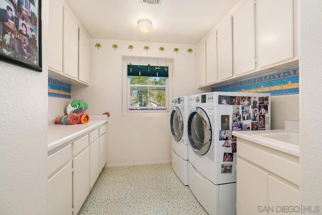 laundry room featuring cabinets and washing machine and dryer