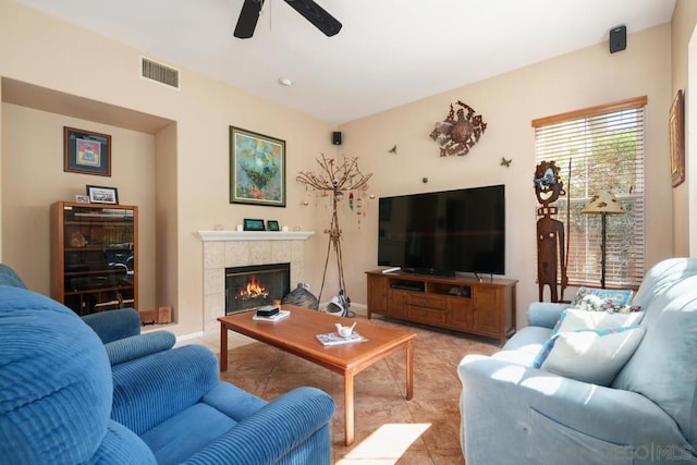 tiled living room with a fireplace and ceiling fan