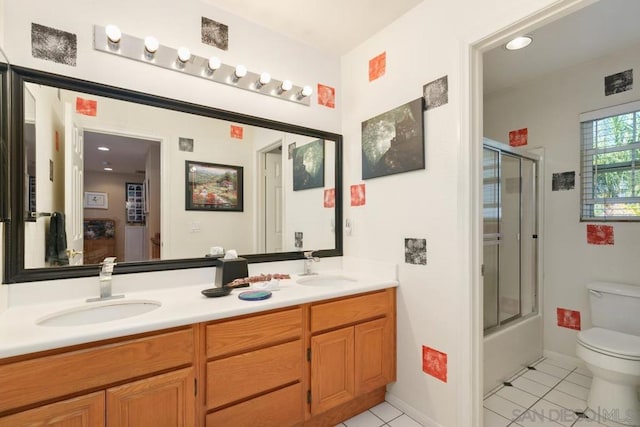 full bathroom featuring vanity, bath / shower combo with glass door, toilet, and tile patterned floors