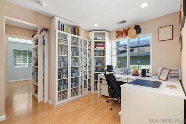 office space with light hardwood / wood-style floors and built in desk