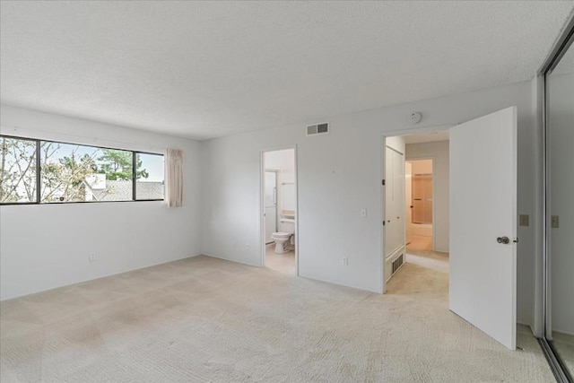 unfurnished room featuring light colored carpet and a textured ceiling