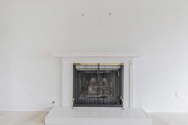 room details featuring carpet flooring and a tile fireplace