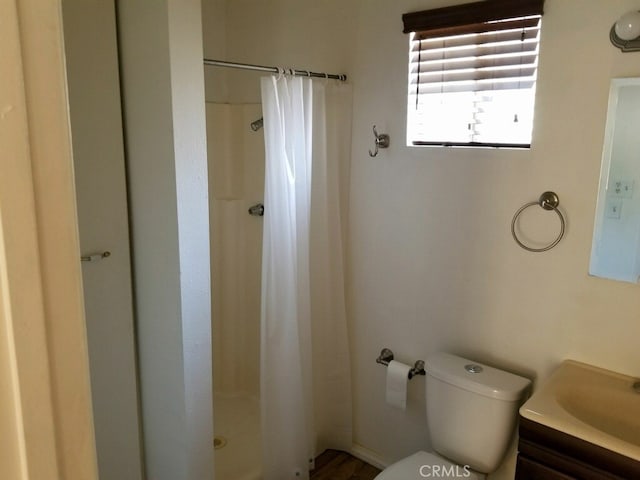 bathroom with vanity, a shower with shower curtain, and toilet