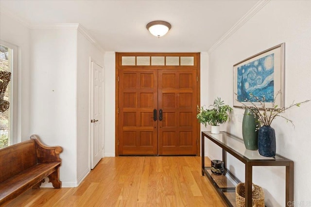 foyer featuring light wood-type flooring and crown molding