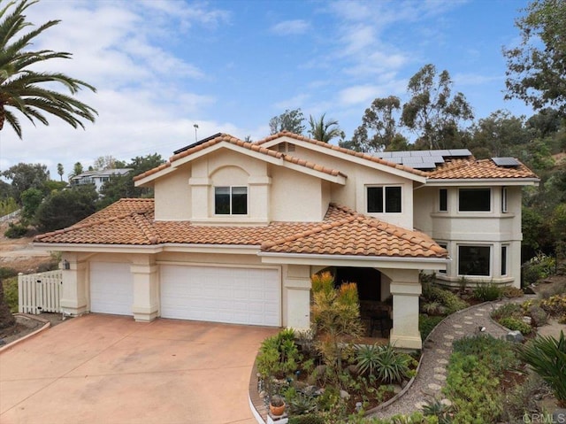 mediterranean / spanish-style home featuring solar panels and a garage