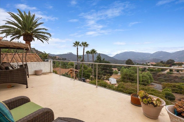 view of patio with a mountain view and a balcony