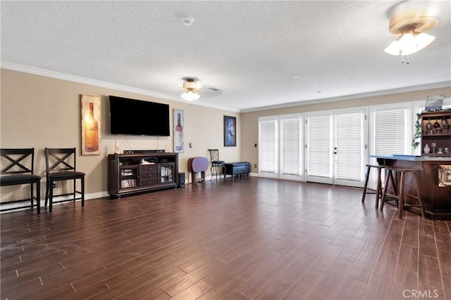 living room with indoor bar, ceiling fan, crown molding, and a textured ceiling