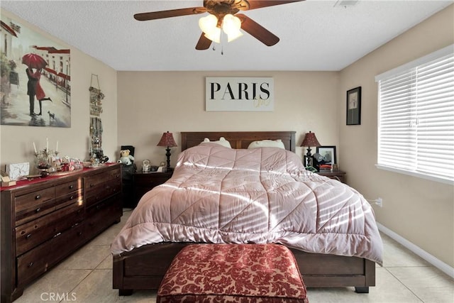 tiled bedroom with a textured ceiling and ceiling fan