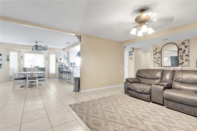 living room featuring a textured ceiling, ceiling fan, and light tile patterned flooring