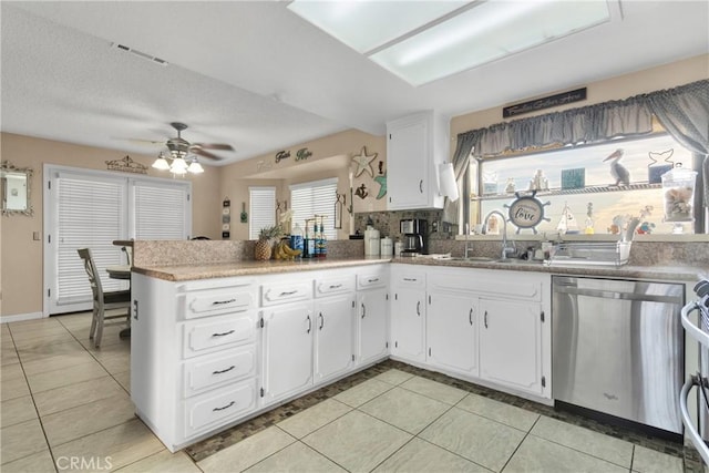 kitchen with sink, white cabinets, dishwasher, ceiling fan, and kitchen peninsula