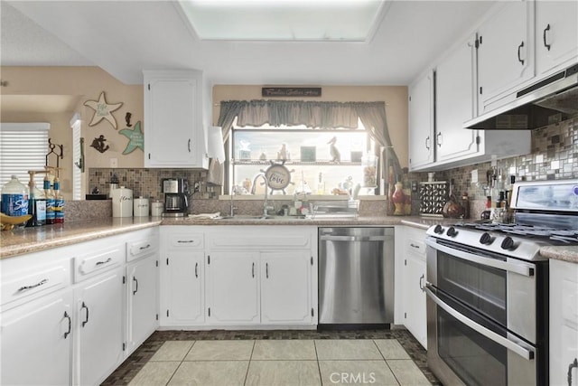 kitchen featuring sink, white cabinetry, tasteful backsplash, light tile patterned floors, and appliances with stainless steel finishes