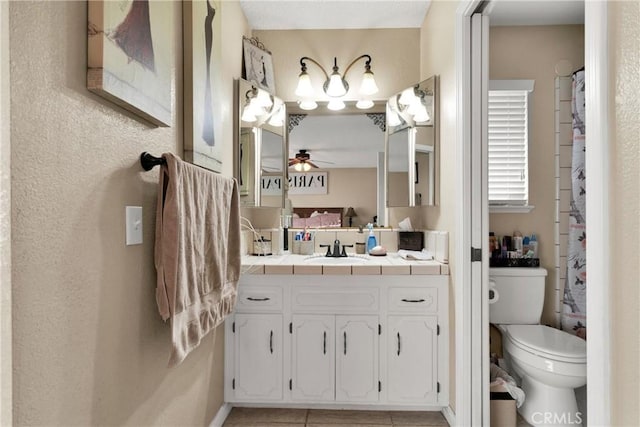 bathroom with toilet, vanity, tile patterned floors, and ceiling fan