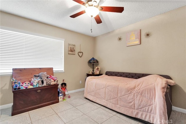 bedroom with ceiling fan, a textured ceiling, and light tile patterned floors