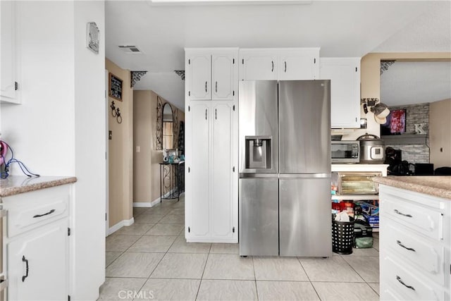 kitchen with light tile patterned flooring, white cabinetry, and stainless steel fridge with ice dispenser