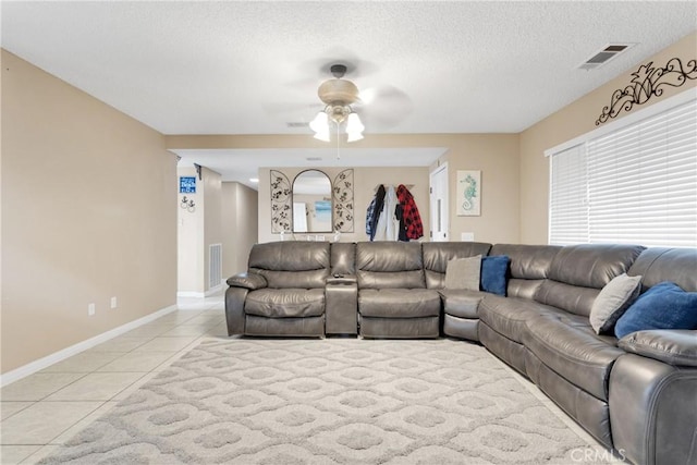 tiled living room featuring a textured ceiling and ceiling fan