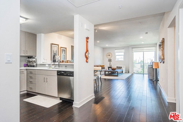 kitchen featuring tasteful backsplash, sink, stainless steel dishwasher, and dark hardwood / wood-style floors