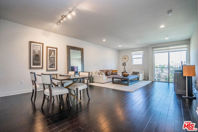 dining room with dark hardwood / wood-style flooring and rail lighting