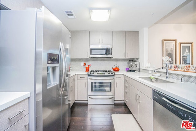 kitchen featuring dark hardwood / wood-style flooring, sink, appliances with stainless steel finishes, and tasteful backsplash