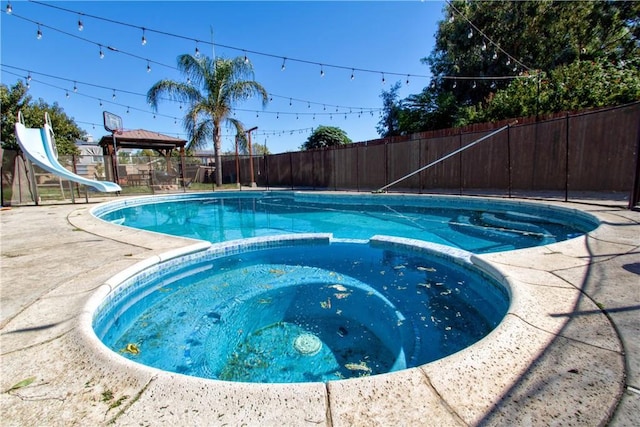 view of pool with an in ground hot tub, a gazebo, a patio area, and a water slide