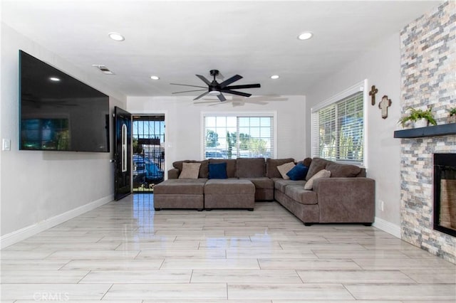 living room featuring a fireplace and ceiling fan