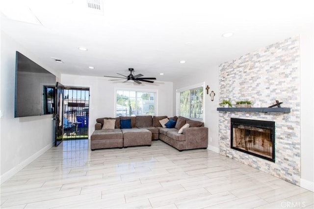 living room featuring ceiling fan and a fireplace