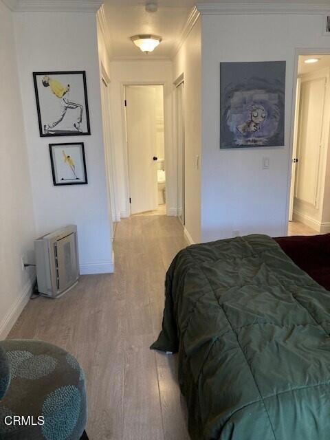 bedroom with hardwood / wood-style floors and crown molding