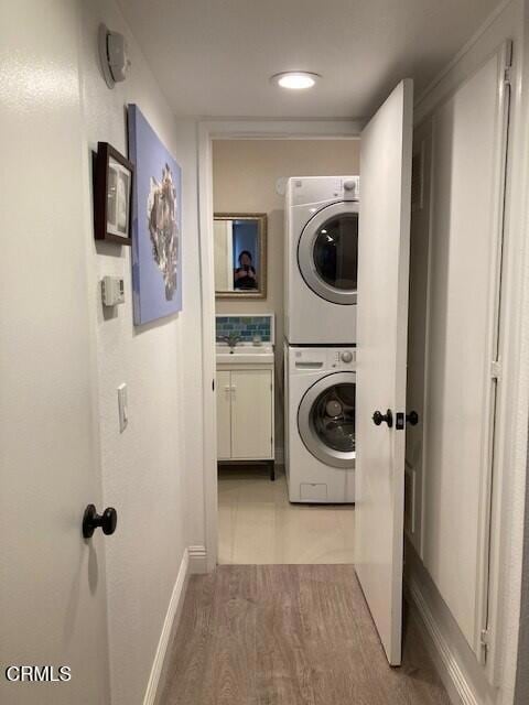 washroom with sink and stacked washing maching and dryer